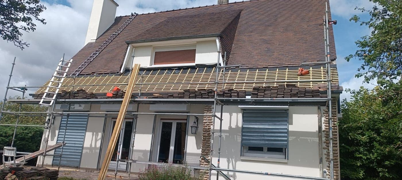 Maison sous échafaudage pendant la dépose de la couverture